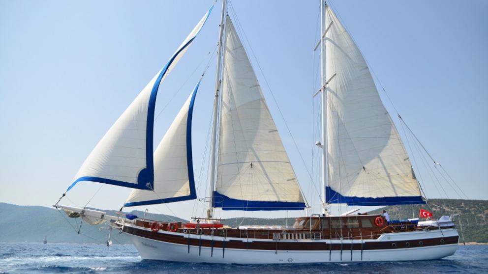 Luxurious gulet Salmakis with raised white and blue sails in the sea